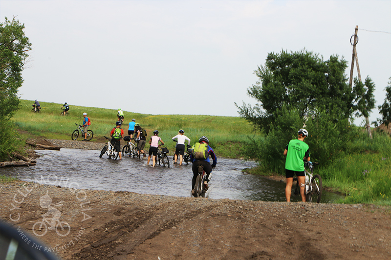 Riders crossing shallow river - Central Mongolia