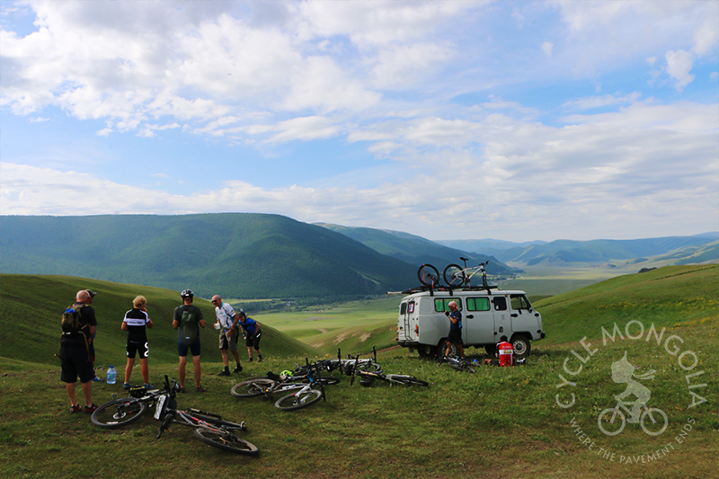 Riders taking a well-deserved break on top of a hill after challenging ascend